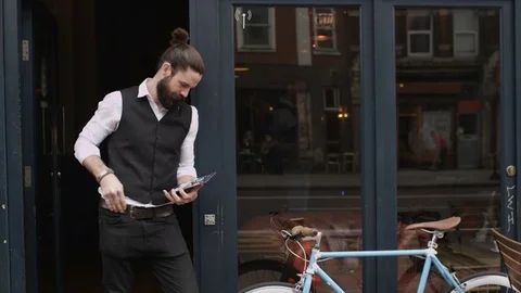4K Smiling Bar Or Cafe Owner Holds Up A Sign To Show He Is Open For Business Stock Footage 75703600