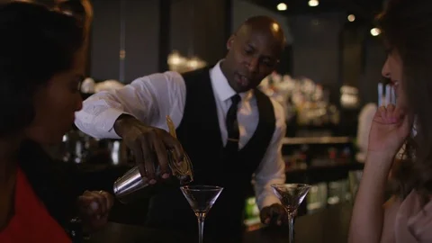 4K Smiling Bartender Prepares &amp; Serves Fresh Cocktails For Female Customers Stock Footage 75741514