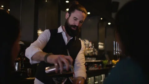 4K Smiling Bartender Prepares &amp; Serves Fresh Cocktails For Female Customers Stock Footage 75742354
