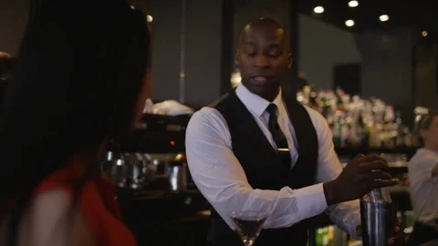 4K Smiling Bartender Prepares &amp; Serves Fresh Cocktails For Female Customer Video stock 75743468