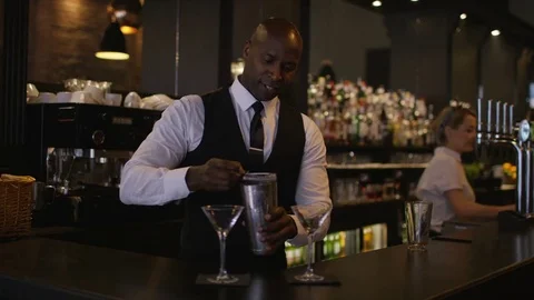 4K Smiling Bartender Prepares &amp; Serves Fresh Cocktails For A Customer Stock Footage 75744614