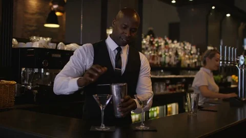 4K Smiling Bartender Prepares &amp; Serves Fresh Cocktails For A Customer Video stock 75744662