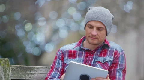 4K Smiling casual man looking at computer tablet in urban park area Stock Footage 55037039
