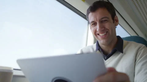 4k Smiling casual man using computer tablet on train journey.  Stock Footage 51970310