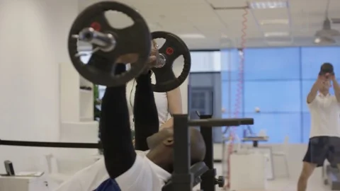 4K Smiling personal trainer helping clients to train in modern gym Video stock 75852432