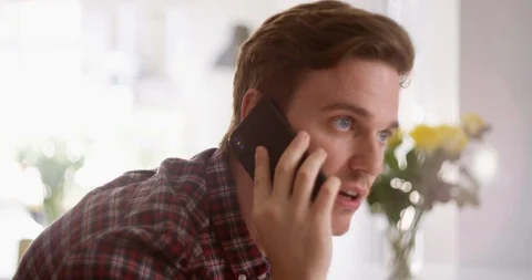 4K Smiling professional man making a friendly phone call in home office Stock Footage 114665661