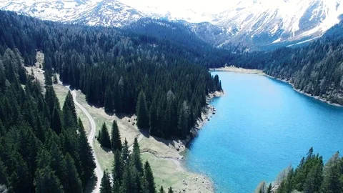 4K smooth aerial drone flight over mountain scene with blue lake, woods, path Video stock 80452149