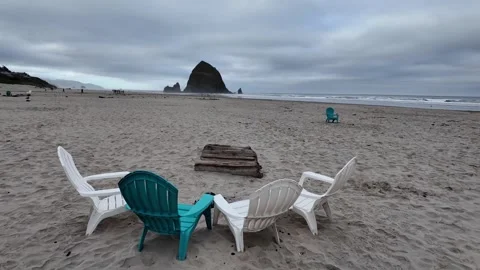4K smooth stabilized footage of empty Adirondack chairs across Cannon beach USA  Stock Footage 339423614