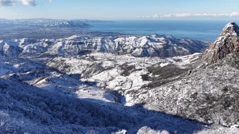 4K Snowy Mountain Overlooking Blue Sea – Static Winter Landscape Video stock 335485298