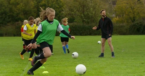 4K Soccer coach training with girls' team shouting encouragement & giving high 5 Stock Footage