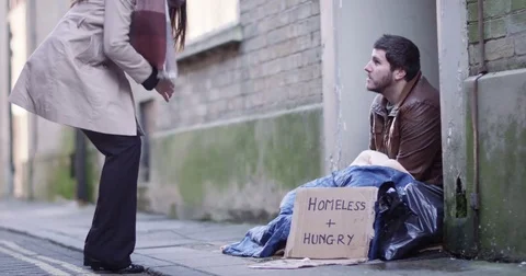 4k, A social worker talking to a homeless man sitting outside in cold Stock Footage 72845795