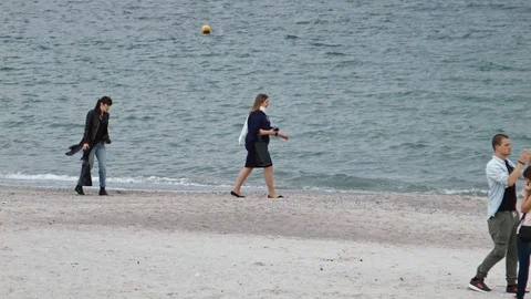 4K Spring Beach, windy day. People are walking along the beach Stock-Footage 99932772