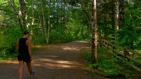 4K Springtime Path, Woman Walking on Country Road, Green Forest Stock Footage 67471816