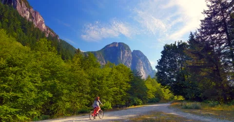 4K Squamish Path with Cyclist in Front of the Chief Mountain Stock Footage 41537649