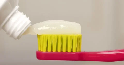 4K - Squeezing toothpaste onto a toothbrush. Close-up Stock Footage 252391660