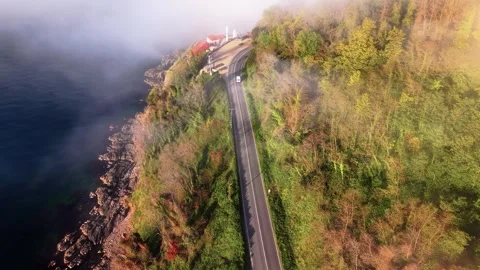 4K Static Aerial of Lighthouse, Sea Fog and White Car at Sunset Stock Footage 339274191