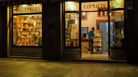 4k static night shot of a pharmacy shop with a woman behind the counter. Stock Footage 122945659