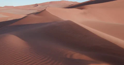 4K static shot of sand blowing over the sand dunes inside the Namib-Naukluft Stock Footage 64697160