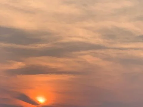 4K Static Sunset with Warm Clouds and Glowing Sun over Jakarta Indonesia Stock Photos