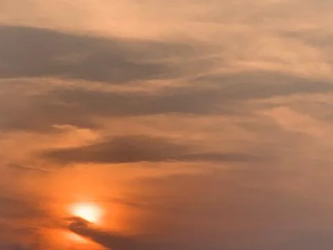 4K Static Sunset with Warm Clouds and Glowing Sun over Jakarta Indonesia Stock Photos