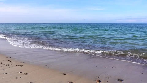 4k static video of a beautiful sandy beach with small ocean waves crashing on Stock Footage 347011295