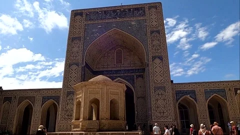 4K static wide shot of historic Kalyan Mosque courtyard with tourists Stock Footage 335542928