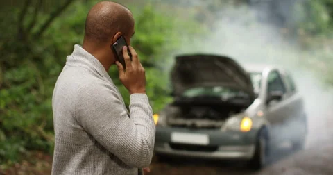 4k, Stranded young man talking on his cellphone with broken down car. Stock Footage 68367051