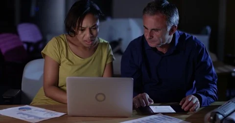 4K Stressed business man &amp; woman working late unhappy about company finances Stock Footage 76740053