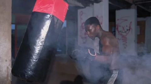 4k Strong boy boxer hitting boxing bag Stock Footage 115914345
