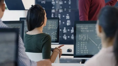 4K Students working on computers &amp; chatting in adult education math class Stock Footage 73177732