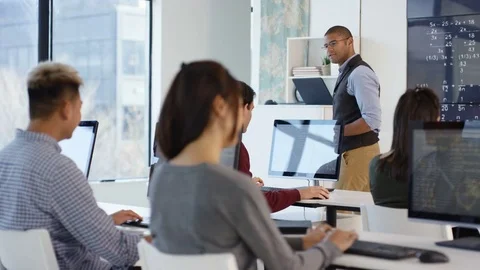 4K Students working on computers & teacher giving help in adult education class. Stock Footage