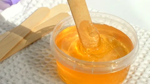 4K. Sugar paste or wax honey in a transparent jar on a white background. Stock Footage 153782919