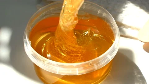 4K. Sugar paste or wax honey in a transparent jar on a white background. Stock Footage 153782943