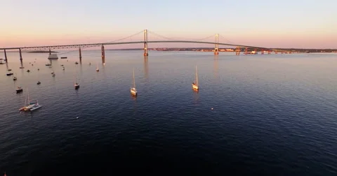 4K Sun setting over Newport Bridge flyover of sailboats in Newport, Rhode Island Vídeos de archivo 63008005