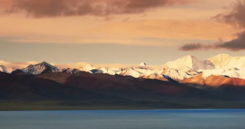 4k sunrise huge clouds mass rolling over lake namtso &amp; snow mountain in tibet. Stock Footage 45581001