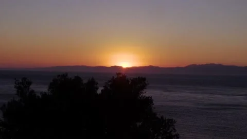 4k Sunset behind mountains next to sea Stock Footage