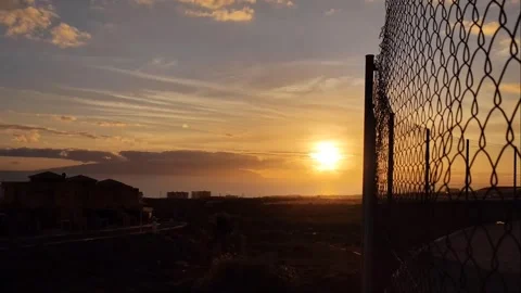 4K Sunset Over Atlantic Ocean and Coastal Town through Chain Link Fence Video stock 334786189