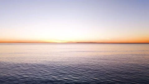 4K Sunset Over Calm Ocean with Distant Island Silhouette Orange Gradient Video stock 332157333
