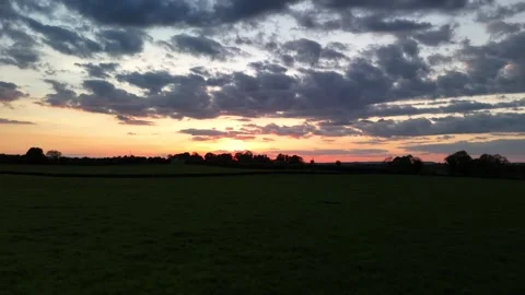 4K Sunset Over Rural Field with Dramatic Clouds Stock Footage 333929077
