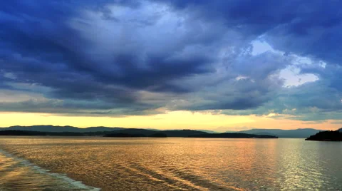 4K Sunset View Off Stern, Dark Blue Clouds, Yellow Dusk and Ship Wake Stock Footage 65559488