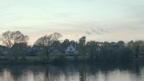 4K Sunset View of a Stunning Lake House with Warm Lights Stock Footage 226232188