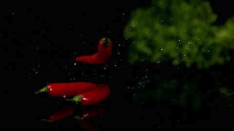 4K Super Slow-Mo Of Chili Peppers Splashing On Wet Black Ground Stock Footage 151445884