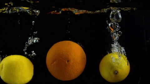 4K Super Slow-Mo Of Couple Lemons And Orange Splashing Into Water Tank Stock Footage 151390623