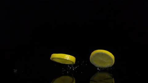 4K Super Slow-Mo Of Lemon Slices Falling On Black Ground Stock Footage 151532711