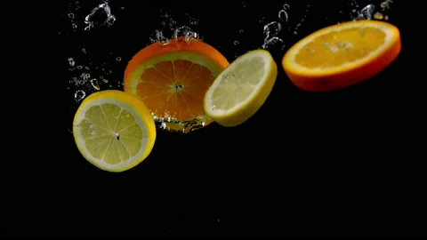 4K Super Slow-Mo Of Lemons And Oranges Falling Into Water Tank Stock Footage 151532507