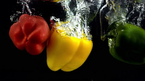 4K Super Slow-Mo Of Three Peppers Splash In Water Tank On Black Background Stock Footage 151393890