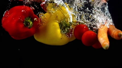 4K Super Slow-Mo Of Veggies Falling In Water Tank On Black Background Stock Footage 151534425
