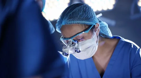 4K Surgeons operating on patient assistant wipes sweat from surgeon's face Stock Footage