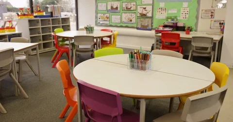 4K Tables with colored pens in school classroom &amp; children's drawings on the wal Stock Footage 74231667