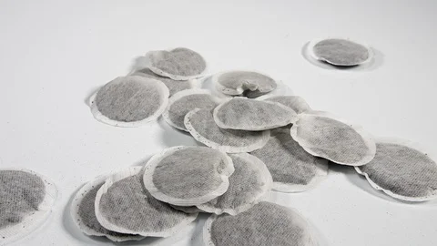 4K Tea bags falling onto white surface , hot British drink on white surface Stock Footage 90029505